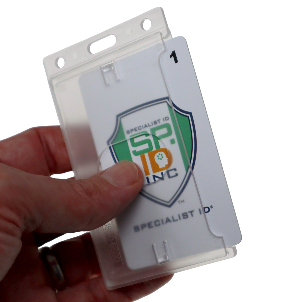 A hand is holding a Side Load Slim Rigid Plastic Badge Holder with Thumb Notch (1840-6500) with a white card inside. The card displays a shield logo with the text "Specialist ID Inc." Ideal for organizations needing bulk wholesale badge holders, this option combines functionality with professional presentation.