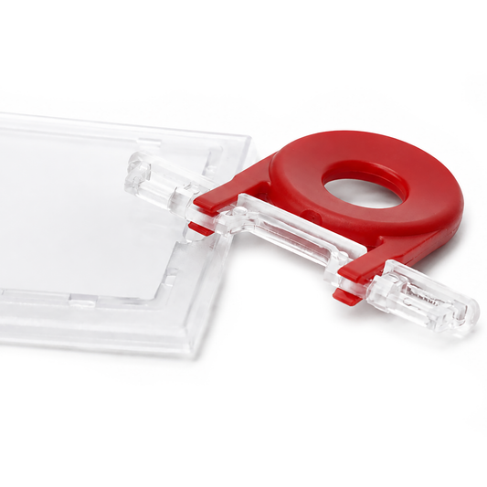 A red plastic clip with a circular hole in the center, used for unlocking badge holders that are locked. Guard Key For Locking Card Holder (P/N 1840-6615).