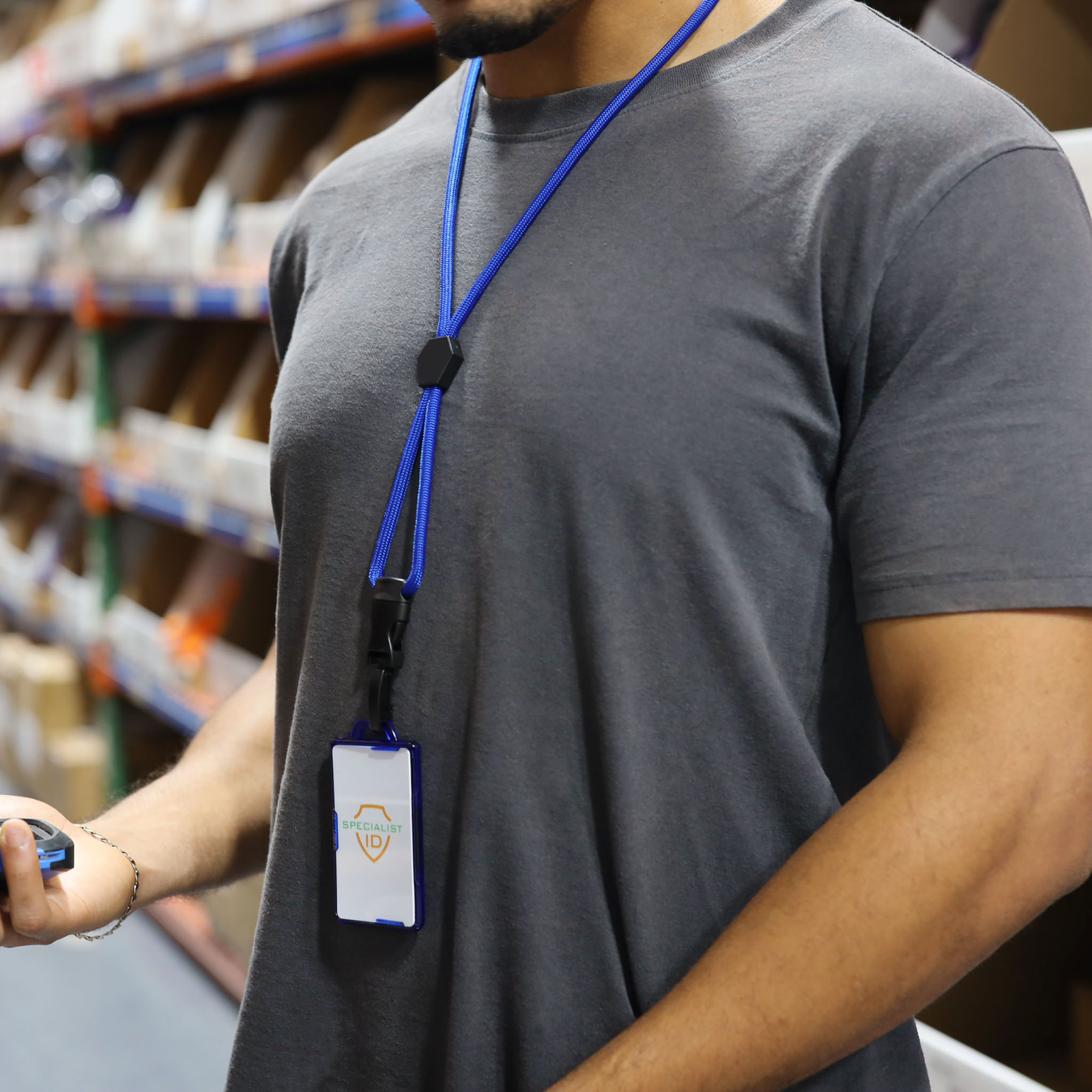 A Specialist ID team member in the warehouse wearing a heavy duty blue lanyard and a rigid badge holder with a Specialist ID card