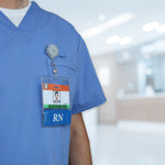 A person in blue scrubs with a customizable title and Custom Printed BadgeBottoms® Horizontal (Badge Holder & Badge Buddy IN ONE) stands in a well-lit hospital or medical facility.