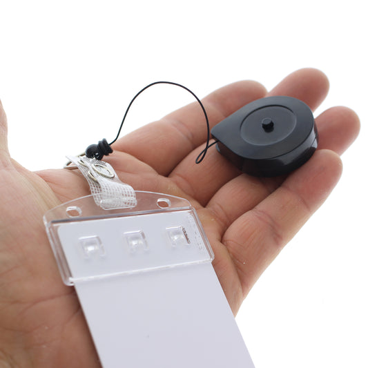 The Lock-A-Reel Self Locking PIV Card Reel, shown held in hand with a clear plastic card sleeve, is ideal for secure ID badge display. Sold by Specialist ID.