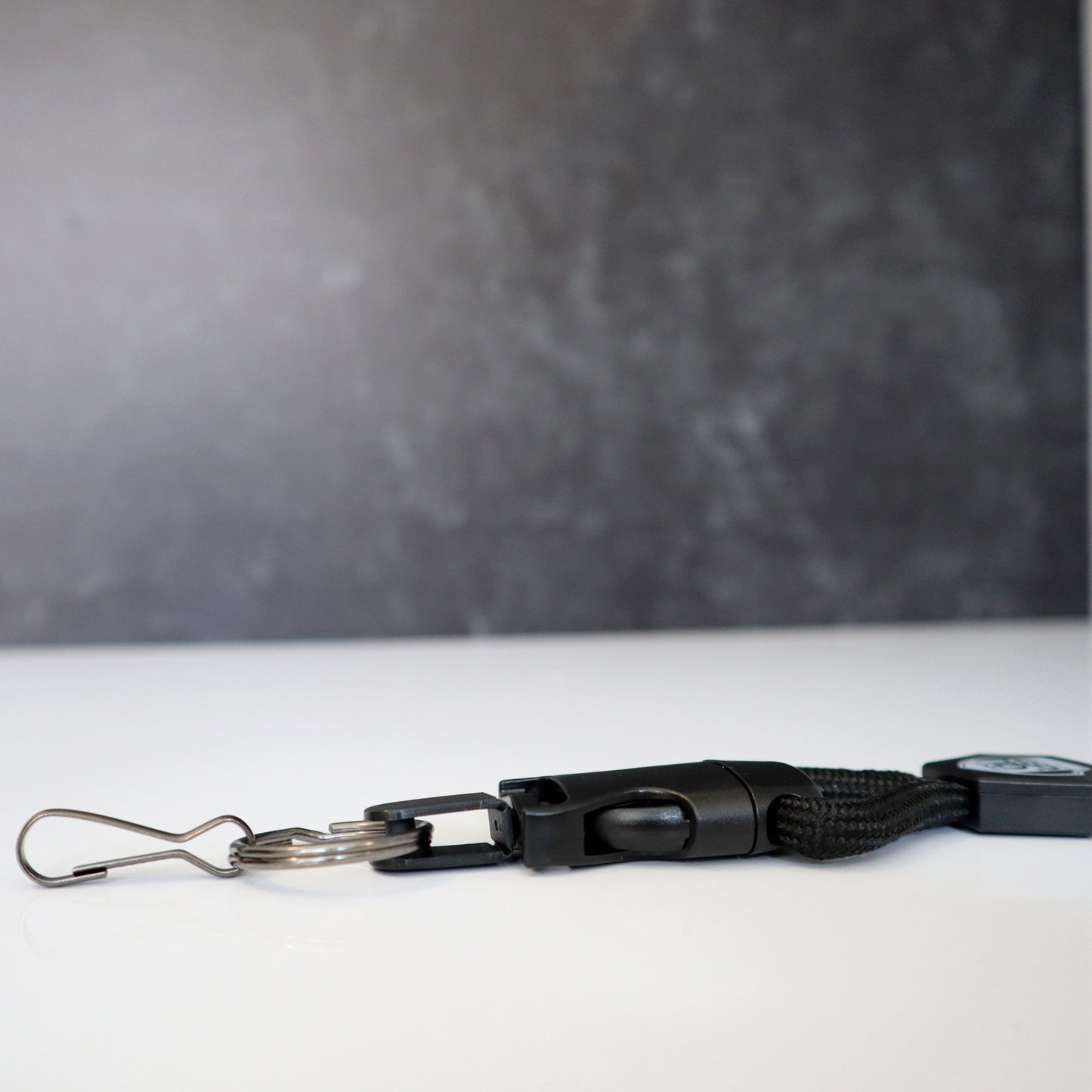 A Heavy Duty Breakaway Lanyard for ID Badges & Keys (SPID-2460), featuring a metal clip and detachable key ring, lies on a white surface. Sold by Specialist ID.
