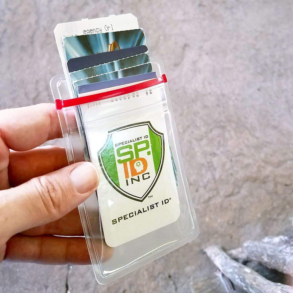 A hand holding several cards inside a clear plastic holder with a red strap. The front card has a logo containing "SF INC" and the text "Specialist ID". The Heavy Duty Vertical Multi-Card Badge Holder with Resealable Zip Top (1815-1110) boasts a resealable top for added security and features a vertical ID display.