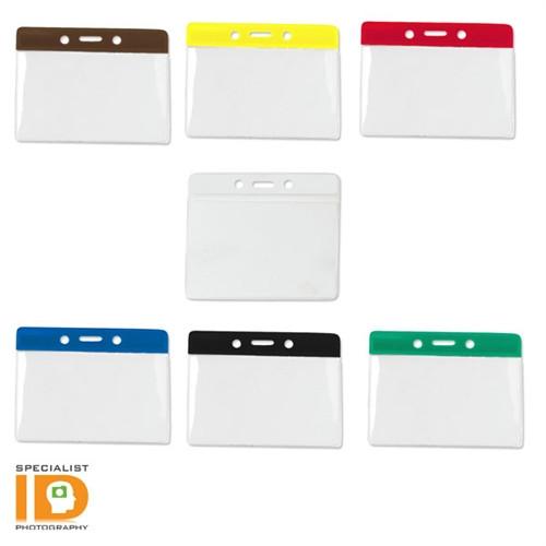 Assorted color-coded name badge holders with transparent pockets, arranged with one holder in the center surrounded by six others. The logo of "Specialist ID" is visible in the bottom left corner. These Government/Military Size Horizontal Vinyl Color-Bar Badge Holder (P/N 1820-110X) are perfect for government or military use.