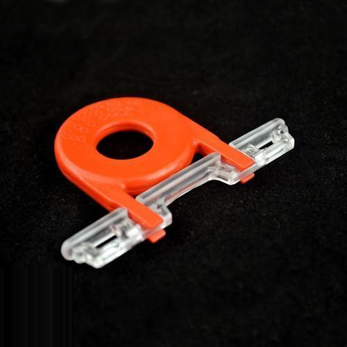 Guard Key For Locking Card Holder (P/N 1840-6615) with a circular hole and transparent locking mechanism, suitable for use as a key for locking rigid card holders, placed on a black background.