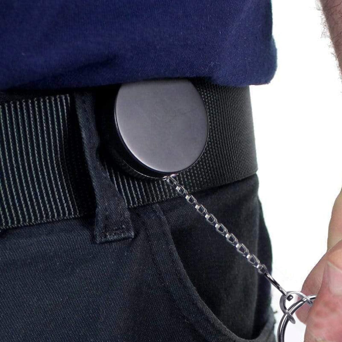 A person attaches a Heavy Duty Badge Reel with Chain & Belt Clip - Strong All Metal Retractable Keychain for Keys and Badges (2120-3325) to their belt loop, making use of its retractable keychain function.