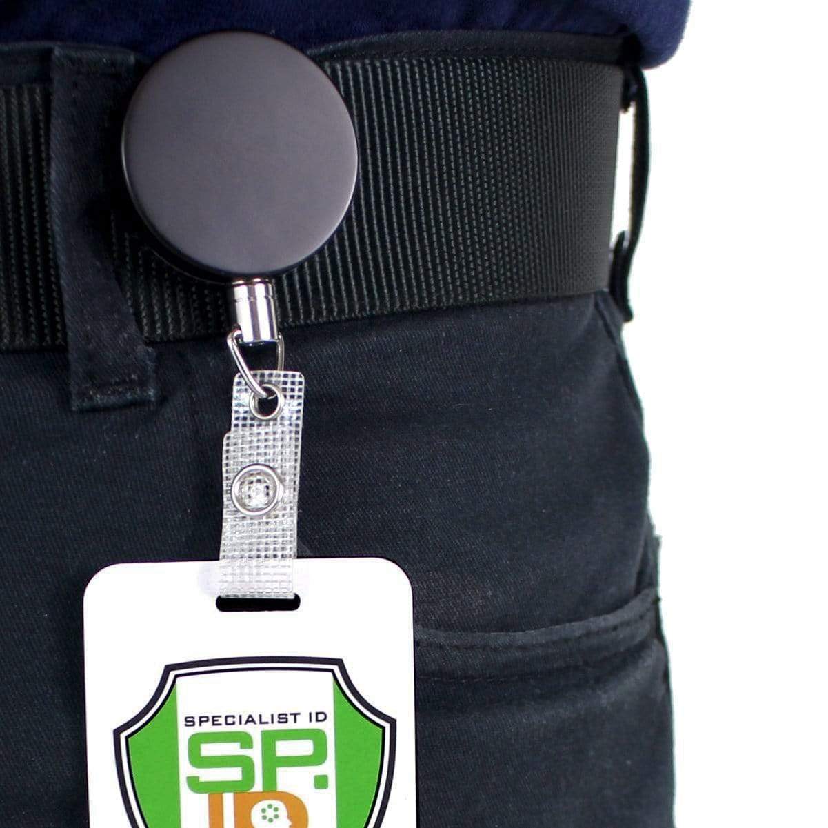 A black, heavy-duty badge reel with a badge clipped onto a black belt. The retractable chain holds the Heavy Duty Badge Reel With Chain (P/N 2120-3375), which features a green, orange, and white design.