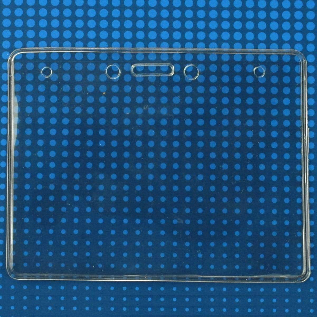 A clear Economical 4 x 3 Horizontal Badge Holder - Clear Vinyl 4x3 Card Holder with Lanyard Slot & Chain Holes with three punch holes at the top, perfect for ID name tags, set against a blue background with small circular patterns.