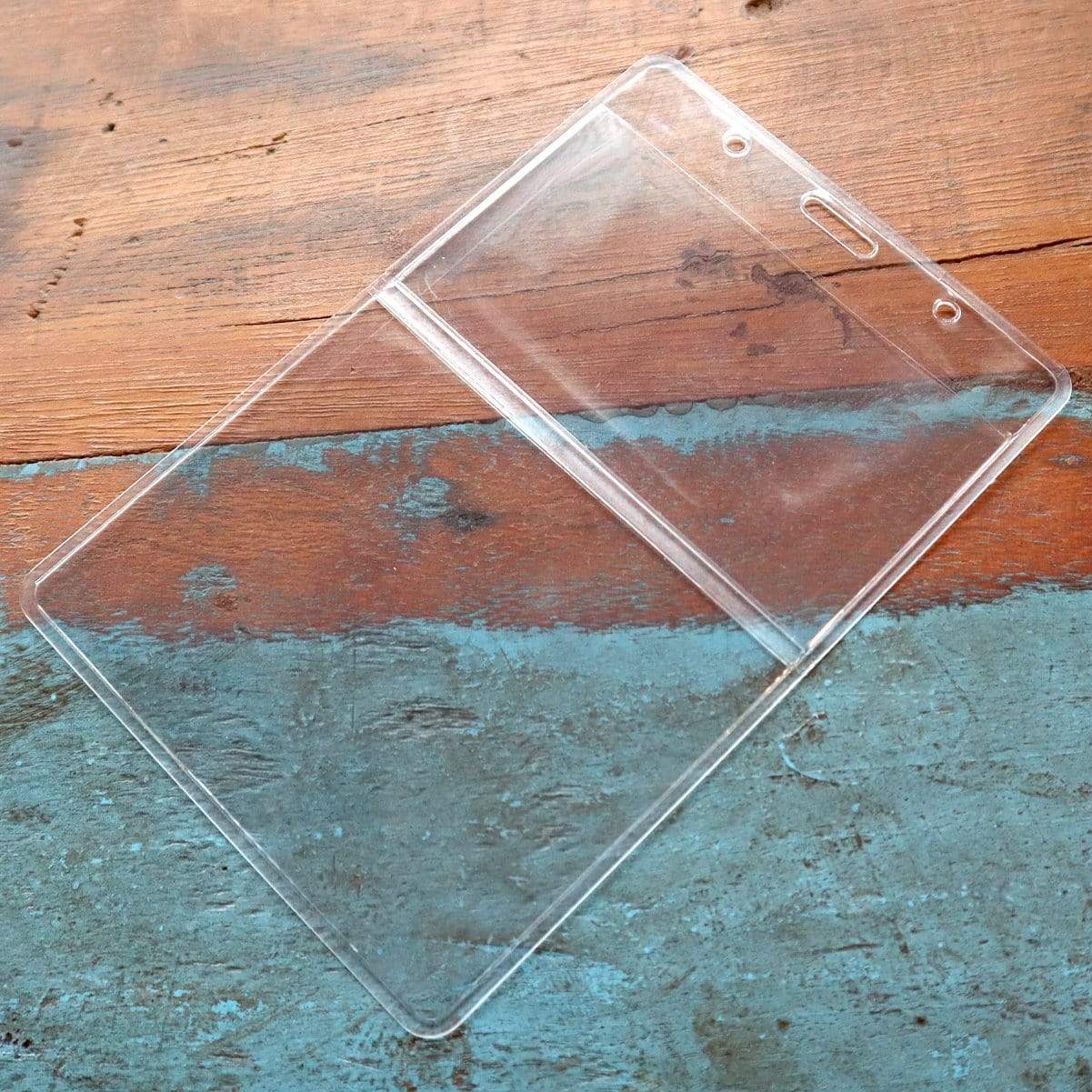 3 5/8 x 5 Special Event Badge & Credential Badge Holder with Business Card Pocket on Back (P/N 306-2P46) on a weathered wooden surface with blue and brown paint.