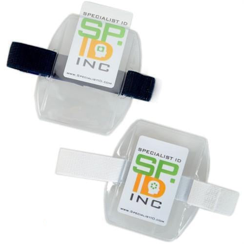 Two Government ID Size Vertical Arm Band Badge Holders with Heavy Duty Vinyl and Hook & Loop Elastic Bands (504-ARFB & 504-ARFW) with "Specialist ID Inc" labels, each featuring adjustable elastic straps—one black, the other white.