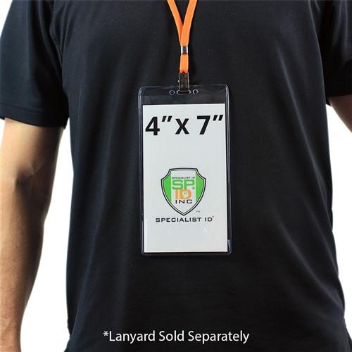 Person wearing a black shirt with a 4 1/8" X 7 1/2" Clear Vinyl Vertical Extra Large Badge Holder (P/N 506-4258) displaying text and a company logo. The extra-large credential holder ensures visibility and durability. Lanyard sold separately is noted at the bottom.