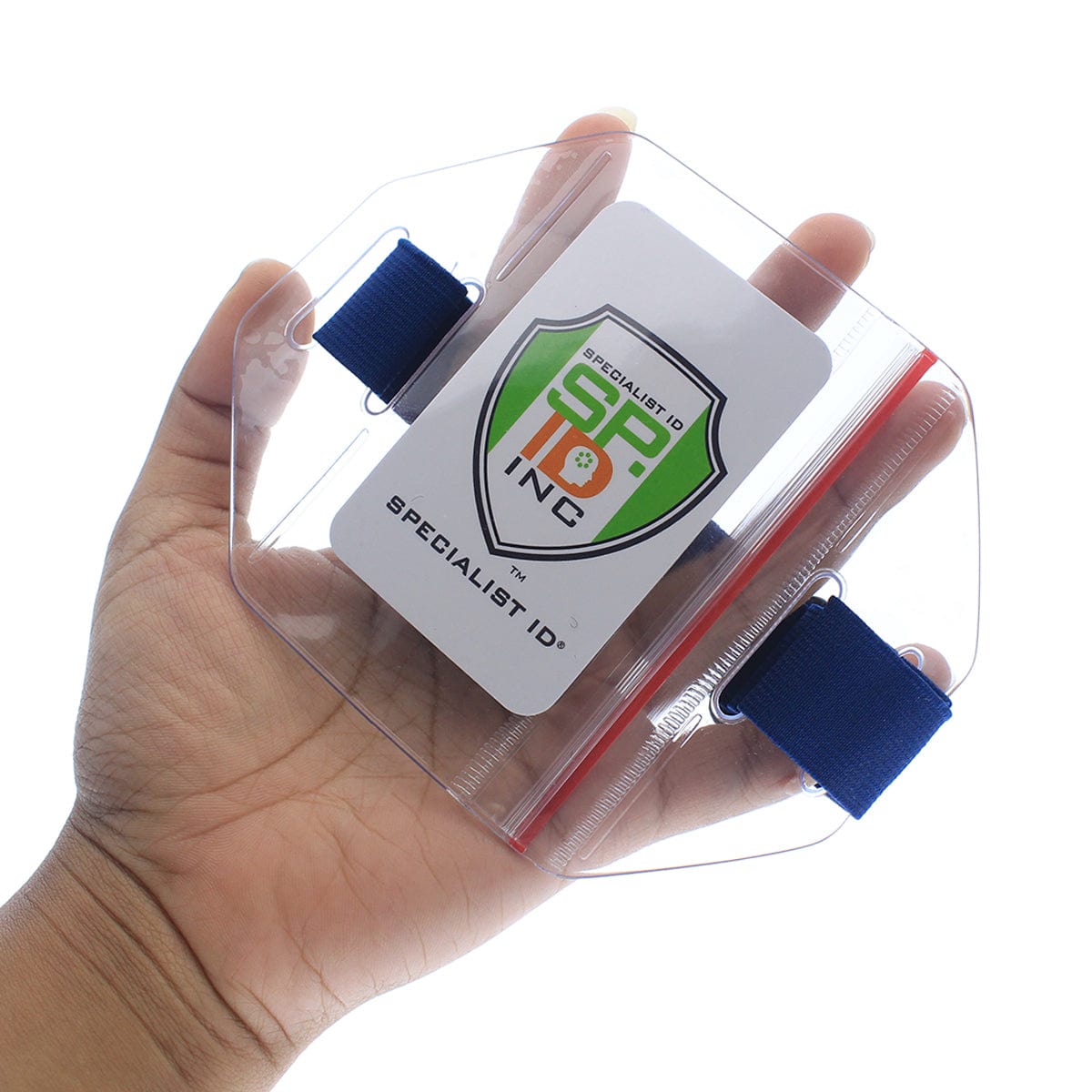 A person holds a transparent, hexagonal Vertical Arm Badge Holder with Elastic Band And Zip Lock Seal (ABH-V-BLU-ZIP) with a logo reading "Specialist ID, INC." It features a blue strap on each side and comes equipped with an elastic band for secure placement.