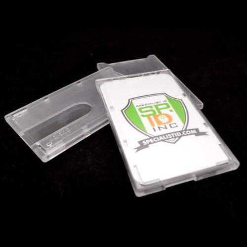 A Top Load Rigid Clear Vertical Badge Holder (AC-915) with a Specialist ID Inc. logo displayed, designed to protect smart card credentials. The rigid badge protector is shown against a black background.
