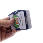 A hand holding a SkimSAFE FIPS 201 RFID Blocking 2-Card ID Holder (AH-210) with two cards visible, one with a shield logo and the text "Specialist ID," the other partially visible behind it.
