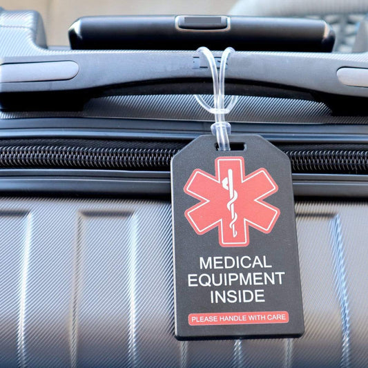 Close-up of a suitcase with a 2 Pack - Heavy Duty Medical Equipment Luggage Tags CPAP / BIPAP with Plastic Loops showing a red medical symbol and text that reads "Medical Equipment Inside. Please Handle with Care.