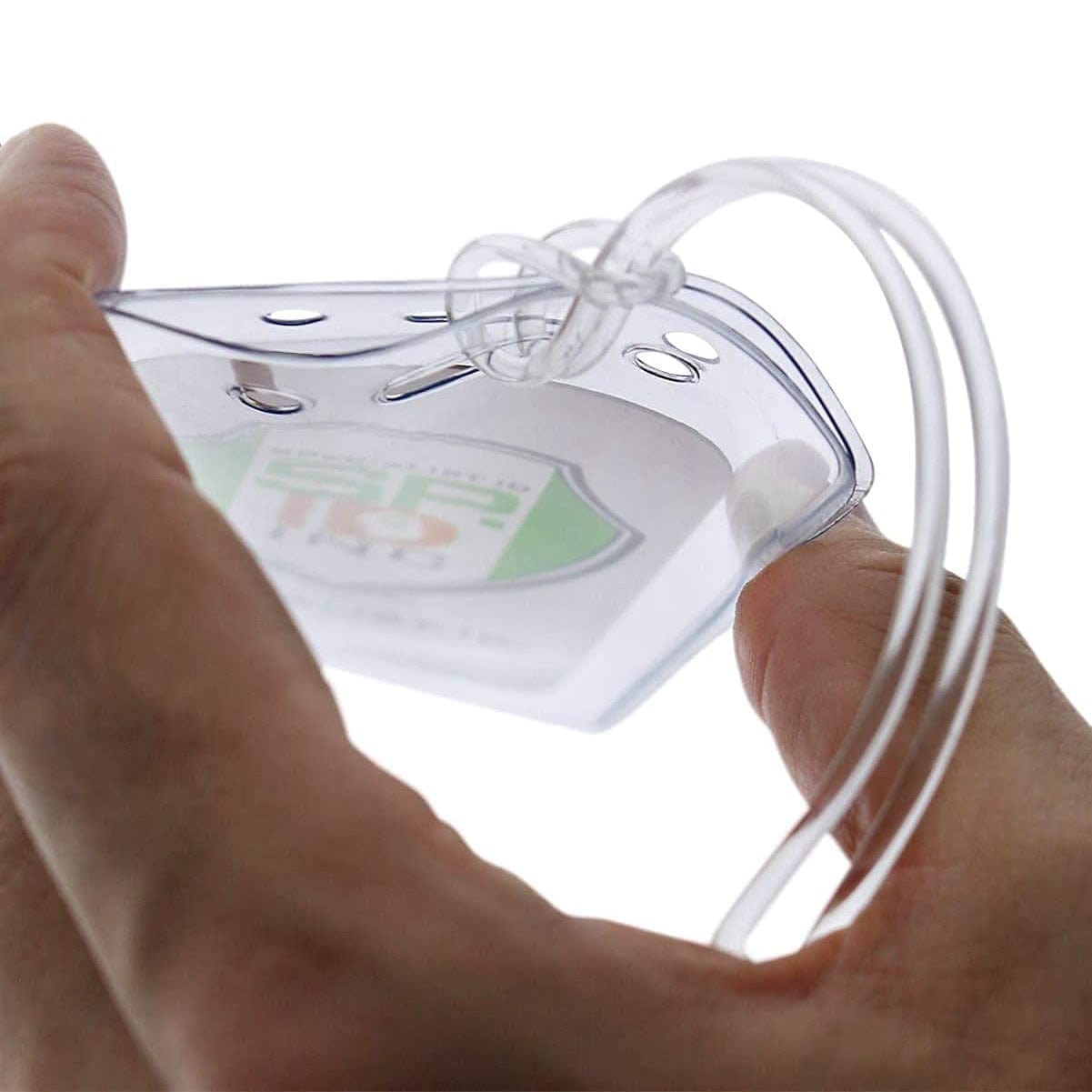 A close-up of a hand holding Clear Plastic Luggage Identification Tags with Loops Included - Business Card or Photo Insert (Locking Top) with secure loops and a transparent lanyard attached through two holes at the top, resembling those on luggage tags.