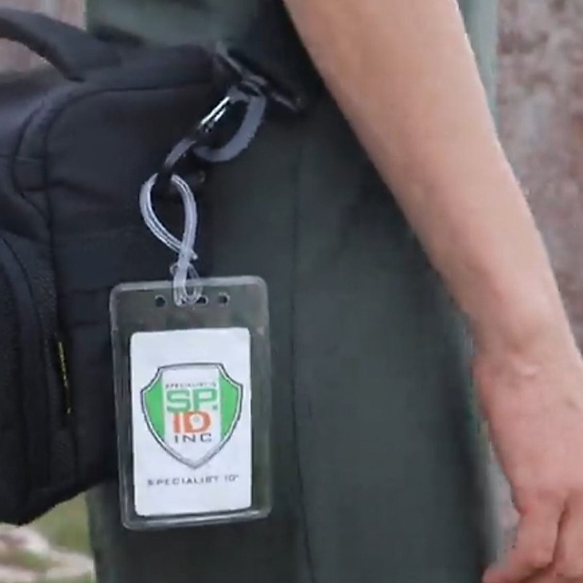 A person carrying a black bag with Clear Plastic Luggage Identification Tags with Loops Included - Business Card or Photo Insert (Locking Top) attached to it, featuring secure loops.