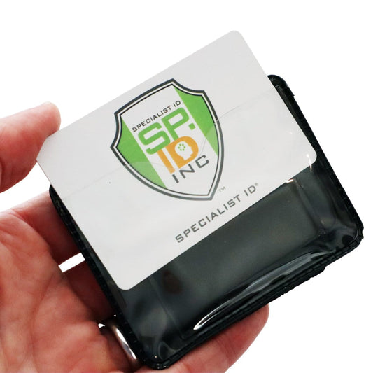 A hand holds a Horizontal Magnetic Badge Holder (P/N 1835-1050) displaying a card with the logo and text "Specialist ID SP Inc." The clear vinyl front enhances visibility, while the strong magnets ensure secure attachment.
