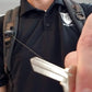 Person with a backpack and black shirt holding a key closely to the camera attached to a SPID Key-Bak SIDEKICK Heavy Duty Retractable Carabiner Badge Reel with ID Holder Strap & Keychain.