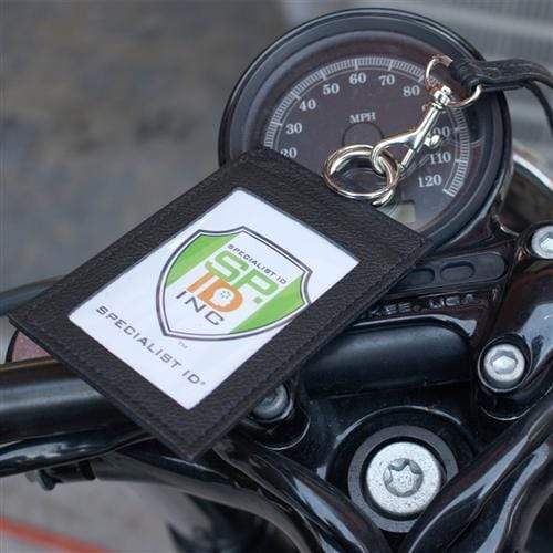 A black leather lanyard with a Heavy Duty Union Made Genuine Leather ID Badge Holder Wallet & Lanyard (SPID-9590-BLACK) hangs on a motorcycle's speedometer.