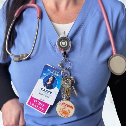 Nurse wearing pink cord KEY-BAK Sidekick badge reel clipped to scrubs