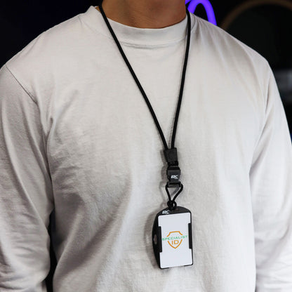 A person wearing a plain white long-sleeve shirt with an EK USA Patriot RFID Blocking Dual Sided Badge Holder with Detachable Lanyard (10943) and an ID badge around their neck, standing against a dark background.