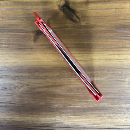 A Custom 2-Sided Rigid Vertical Multi-Card Holder (1840-308X) - Add Your Logo with its blade retracted, placed horizontally on a wooden surface, exudes a professional look.