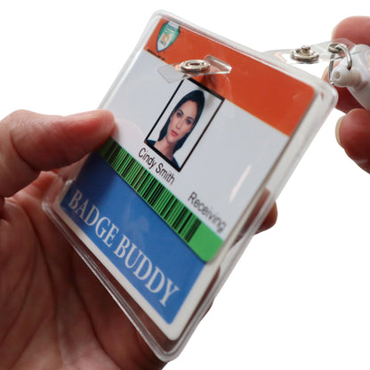 Close-up of a hand holding an identification badge in a plastic holder with a slot opening for a strap clip. The badge displays a photo, name "Cindy Smith," and title "Receiving," featuring an attached colored Horizontal Badge Buddy Holder (P/N 1840-5014) below.