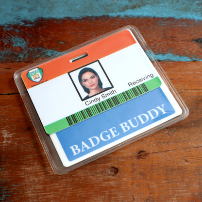 The image depicts an employee ID badge for Cindy Smith in the Receiving department, featuring a photo, name, and barcode. The badge is securely placed in a vinyl pocket enclosure with an additional Horizontal Badge Buddy Holder (P/N 1840-5014) attached for extra clarity.