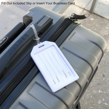 A close-up of a grey suitcase with a white Custom Rigid Plastic Luggage Tag Holders with 6" Clear Loop - Personalize with Your Logo attached. The tag includes fields for name, address, telephone, and email. Text above reads, "Fill out included slip or insert your business card.