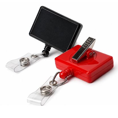 Two Rectangle Badge Reel Retractable with Rotating Swivel Clips (2120-390X), one black with a blank label and one red with a metal clip, are displayed side by side on a white background.