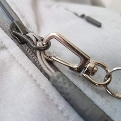 Close-up of the Custom Retractable Ski Pass Holder - Heavy Duty Sport Reel (2120-4101) with a metal carabiner on a grey zipper pull, ideal for adding your logo as a customizable promotional item or ski pass holder.
