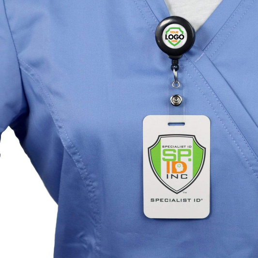Person wearing a blue scrub top with a lanyard and Standard Custom Printed Badge Reels w/ No Twist Design - Add Your Logo to Personalize, featuring the logo "Specialist ID Inc," promoting brand awareness and reinforcing a professional image.