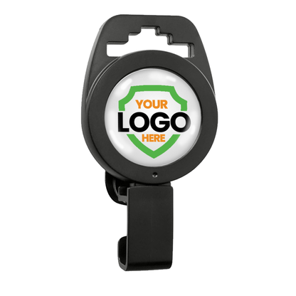 A Custom Non-Magnetic Badge Reel with Plastic Clip - No Twist Design - Add Your Logo features a retractable center displaying a circular, white area adorned with a green and orange shield design and placeholder text, "YOUR LOGO HERE." This personalized logo option ensures your branding stands out.