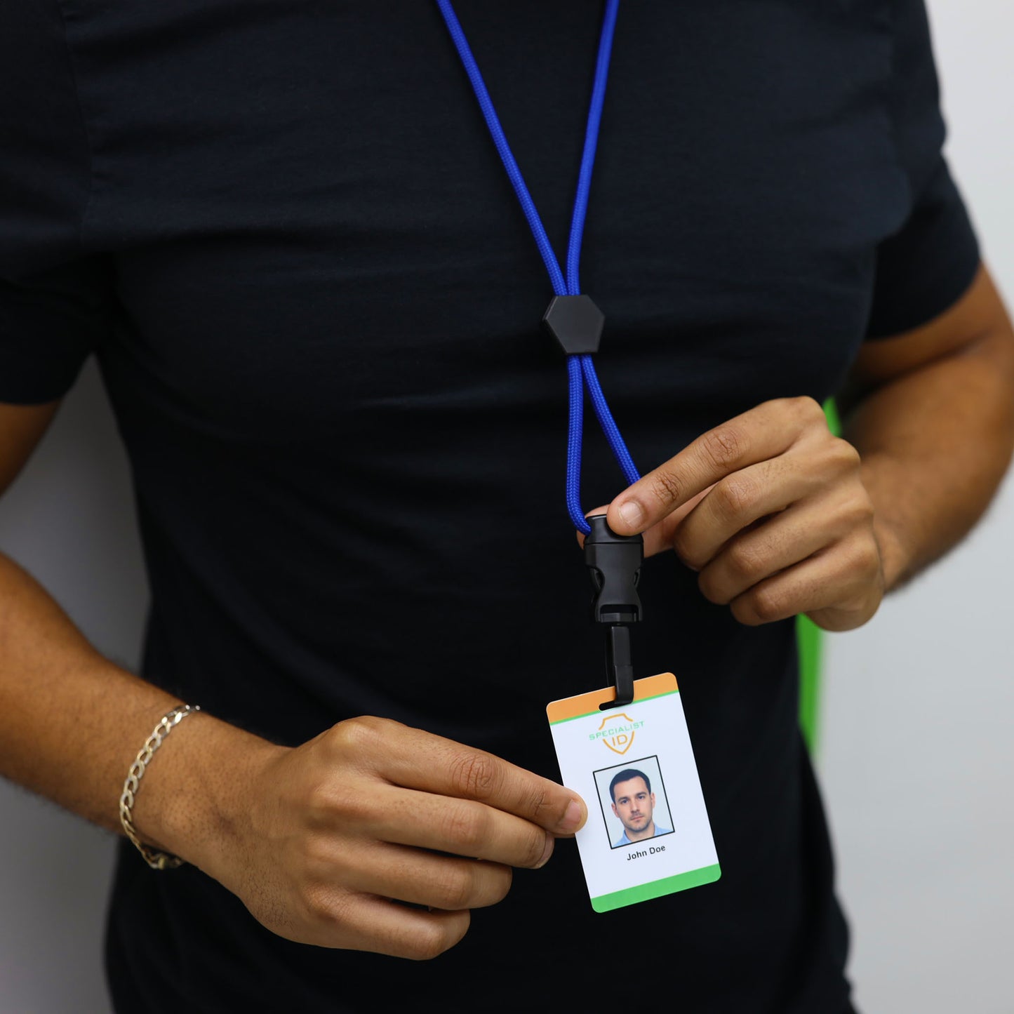 A person wearing a black shirt holds an ID badge attached to the Metal Detector Friendly Heavy Duty Lanyard with Diamond Slider, Breakaway Clasp & Quick Release Plastic Hook - MRI Safe (2135-45XX), displaying a photo and text against a plain background.