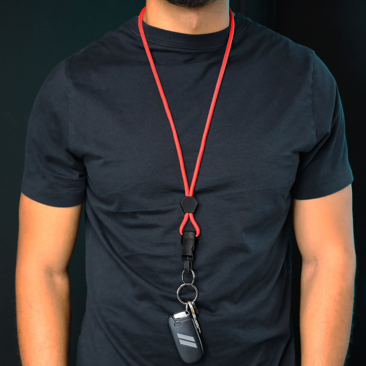 Person wearing a black t-shirt and a Heavy Duty Breakaway Round Lanyard With Detachable Key Ring (2135-454X) around their neck, holding keys and a key fob.