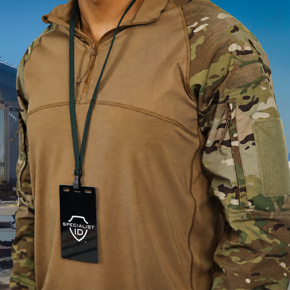 A person is wearing a brown and camouflage long-sleeve shirt with a black Breakaway Lanyard with No Twist Plastic ID Clip – MRI and Metal Detector Friendly (2137-474X), holding an ID badge labeled "Specialist ID," while standing outdoors.