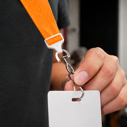 A person holds a blank white ID badge on a Flat Wide Breakaway Lanyard with Swivel Hook - 5/8 Inch Width (2138-500X), orange, with a nickel-plated steel swivel hook.