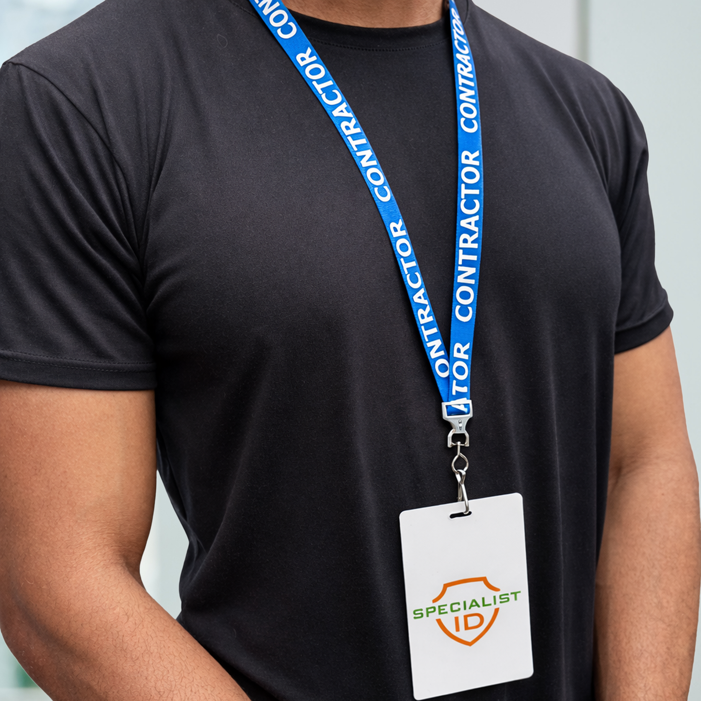 Person wearing a black t-shirt with a blue "CONTRACTOR" lanyard and attached 'Specialist ID' ID badge.