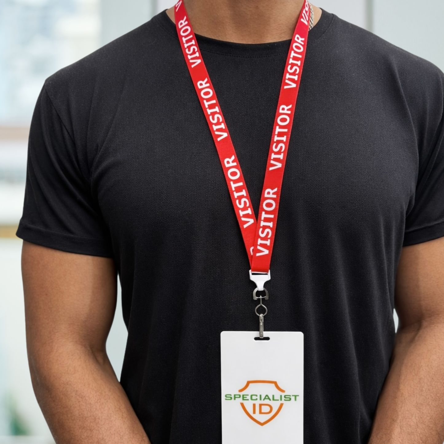 Person wearing a black t-shirt with a red 'VISITOR' lanyard with swivel hook (P/N 2138-5220) and attachedand Specialist ID badge. 