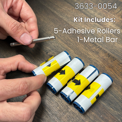 A hand holds a Magicard 3633-0054 Cleaning Roller Kit with Metal Bar (5 Pack) on a wood surface, showing 1 metal bar and 5 adhesive rollers—perfect for maintaining your Magicard ID card printer.
