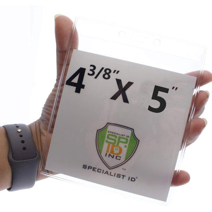 A hand holding a 4 3/8 x 5" Clear Vertical Large Event Badge Holder (P/N 306-4755) displays a piece of paper labeled "4 3/8" X 5" with a Specialist ID logo.