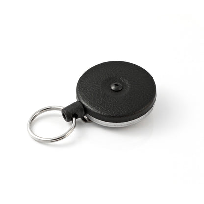 A black, circular Key-Bak #485B-HDK Self Retracting Key Reel with a metal keyring attached, featuring a durable Kevlar cord for enhanced security enforcement, on a white background.