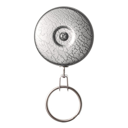 A Key-Bak #5 Self Retracting Key Badge Reel with a metal clip attached to a circular backing, featuring a Kevlar cord for added durability and a keyring at the bottom, viewed from the front.
