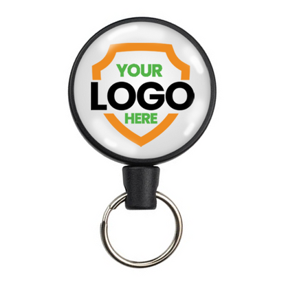 Round keychain with a retractable badge holder displaying the text "YOUR LOGO HERE" inside an orange shield graphic. Perfect for promoting brand awareness, these Customizable Key-Bak Mid Size Key Ring Badge Reels with Belt Clip (#6) - Add Your Logo allow you to personalize your key bak with ease.