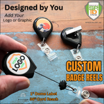 Specialist ID branding custom badge reels with an artsy graphic design and the back side spring clip. A hand holding one shows the cord being extended on a wooden surface with "Your Logo Here" in the center 1 inch circle.  