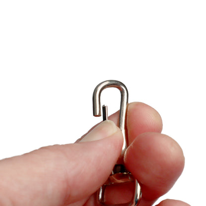 A hand holds a 1 3/4" Non Swivel J Hook with Rectangular End - DIY Lanyard and Craft Accessories (6920-2400) with an open latch against a white background.