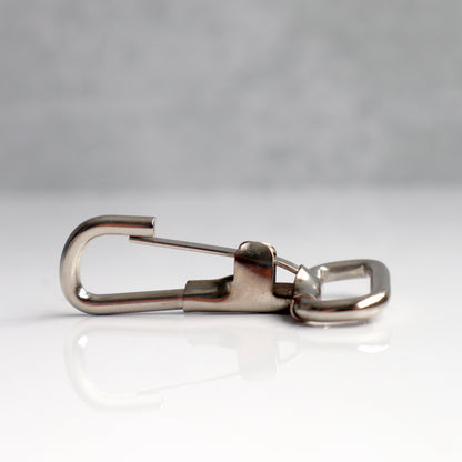 Close-up of a 1 3/4" Non Swivel J Hook with Rectangular End - DIY Lanyard and Craft Accessories (6920-2400) made from corrosion-resistant steel, lying on a flat surface against a gray background.