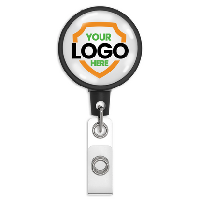 A Customizable Key-Bak Mid Size ID Badge Reel with Steel Belt Clip (6ID) - Upload Your Logo with customizable text reading "Your Logo Here" on a white background featuring an orange and green shield design. Enhance brand awareness with this badge holder, which includes a convenient clip at the bottom.