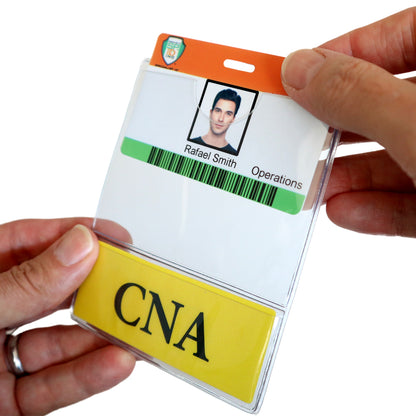 A close-up of hands holding a medical ID badge with a photo, labeled "Rafael Smith, Operations" and a larger insert labeled "CNA BadgeBottom Badge Holder & CNA Badge Buddy IN ONE!! - Horizontal ID Badge Sleeve with Bottom Role Tag for Nurse Assistants.